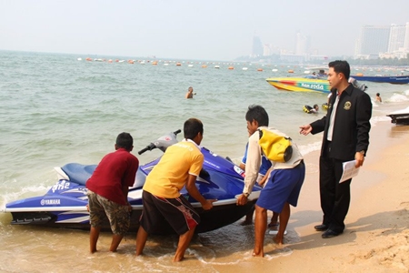 Mayor Itthiphol Kunplome inspects a jet ski and talks with the vendors on Pattaya Beach.